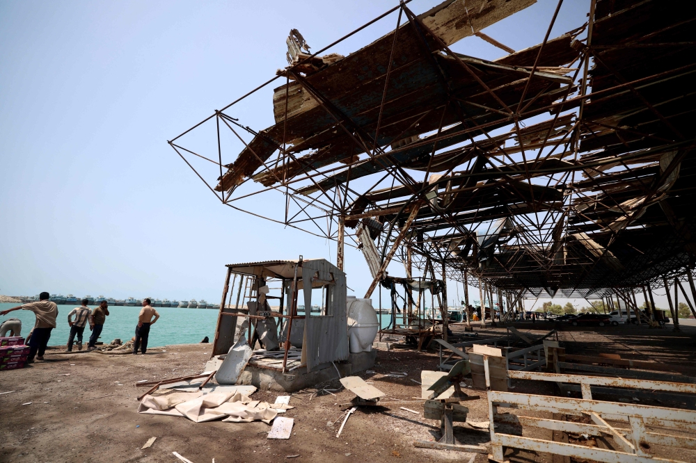 Men gather at the damage to the storage and warehousing facilities at the port of Kuhestak following a US military strike earlier in the week on Kuhestak, Sirik County, in Iran's southern Hormozgan province September 6, 2026. — AFP pic