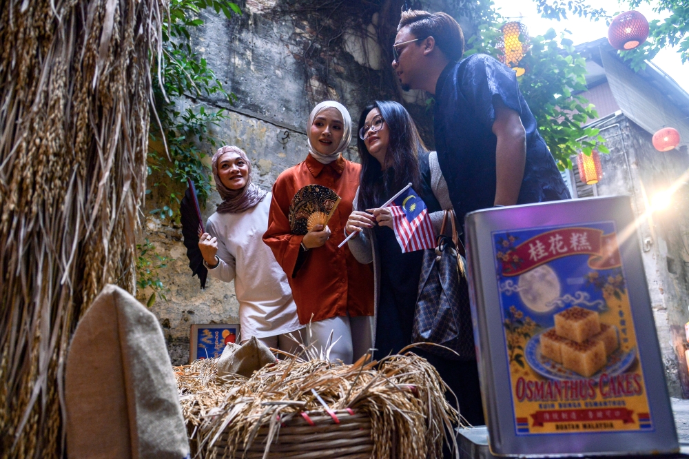 Content creator Rachel Loh (second, right) and her friends explore the Mid-Autumn Festival art installation during a media preview at Kwai Chai Hong. — Bernama pic 