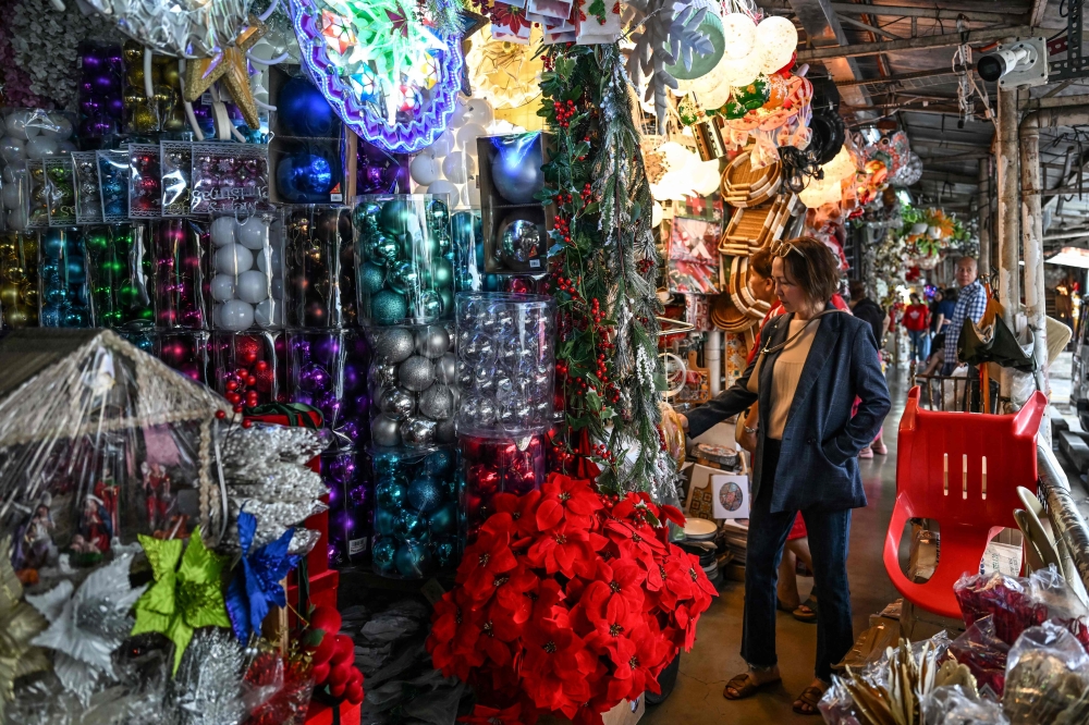 A woman shops for Christmas decorations at a market in Quezon City, Metro Manila, on September 4, 2026, as Filipinos begin their traditional four-month “ber months” countdown to Christmas. — AFP pic