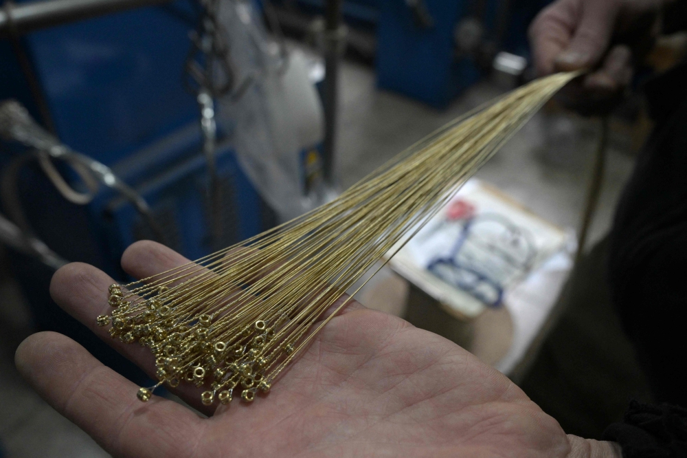 A worker manufactures string cords for bass guitars at the Martin Blust factory of strings for musical instruments in Munro, Vicente Lopez, Buenos Aires province, Argentina on August 27, 2026. — AFP pic