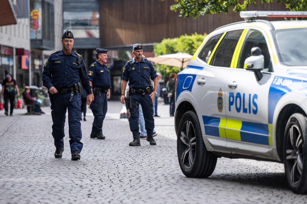 Swedish police patrol a street outside the Farsta metro station in Farsta, south of Stockholm in a bid to quell a decade-long gang violence involving automatic weapons, grenades and explosives. — AFP pic
