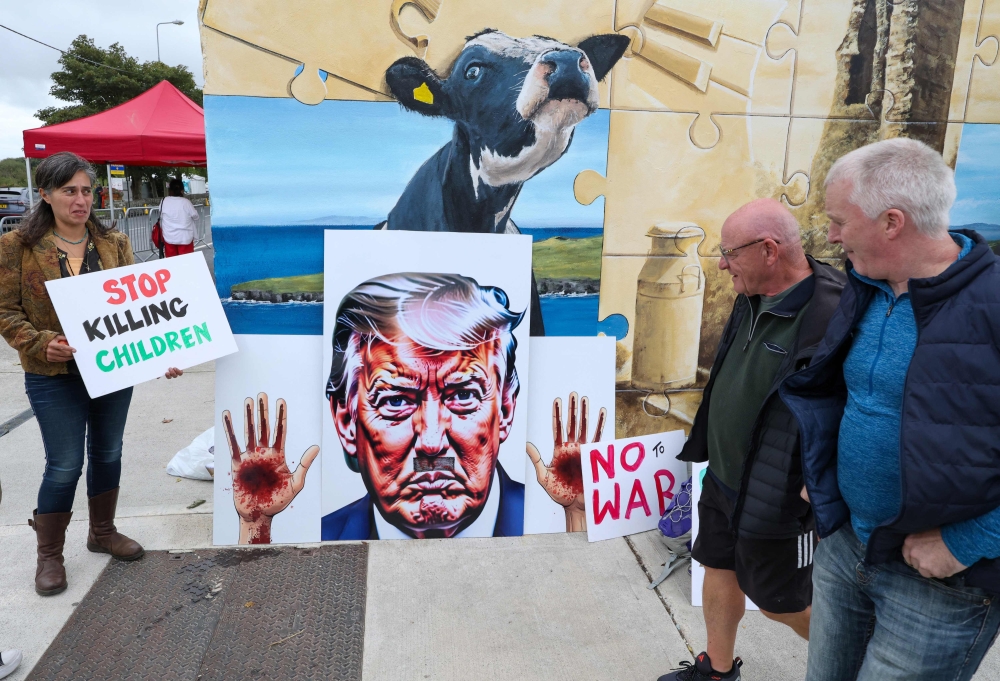 Protesters hold placards against US President Donald Trump’s visit in Doonbeg, western Ireland on September 12, 2026, where he is attending the Irish Open golf tournament. — AFP pic