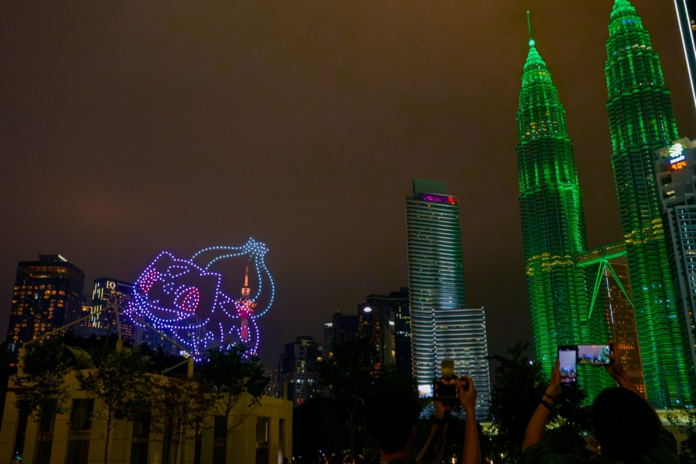 The Petronas Towers glowed green to match Bulbasaur, a delightful syncing along to the performance. — Picture by Raymond Manuel