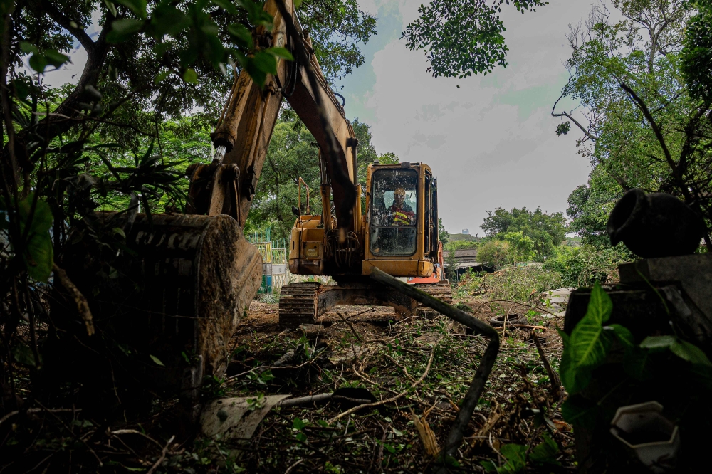 An excavator clears resumed land in Kwu Tung, northern New Territories, on June 23, 2026. — AFP pic