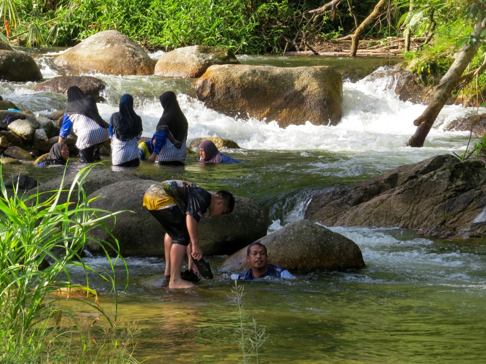Visitors cool off in Dakoh’s river at Pos Balar, enjoying swimming and other water activities. — Bernama pic
