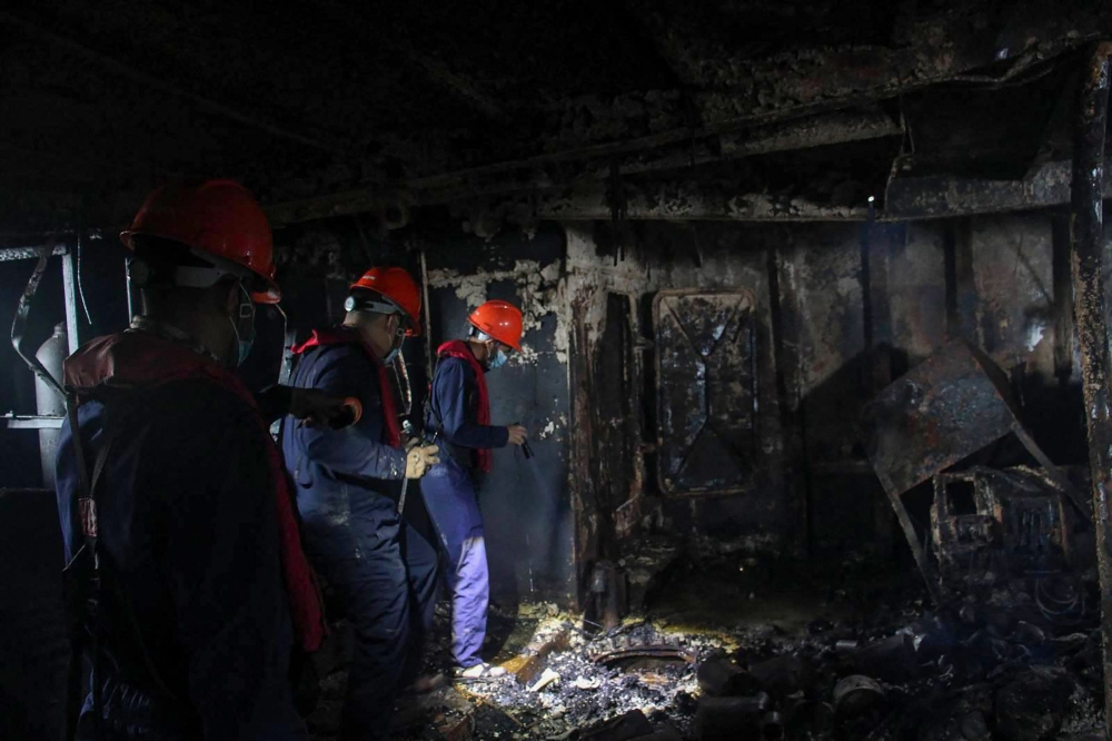 Philippine Coast Guard staff inspect a burnt section of the M/V June Aster ferry off the shores of Coron town, Palawan province on September 11, 2026. — Philippine Coast Guard handout pic via AFP