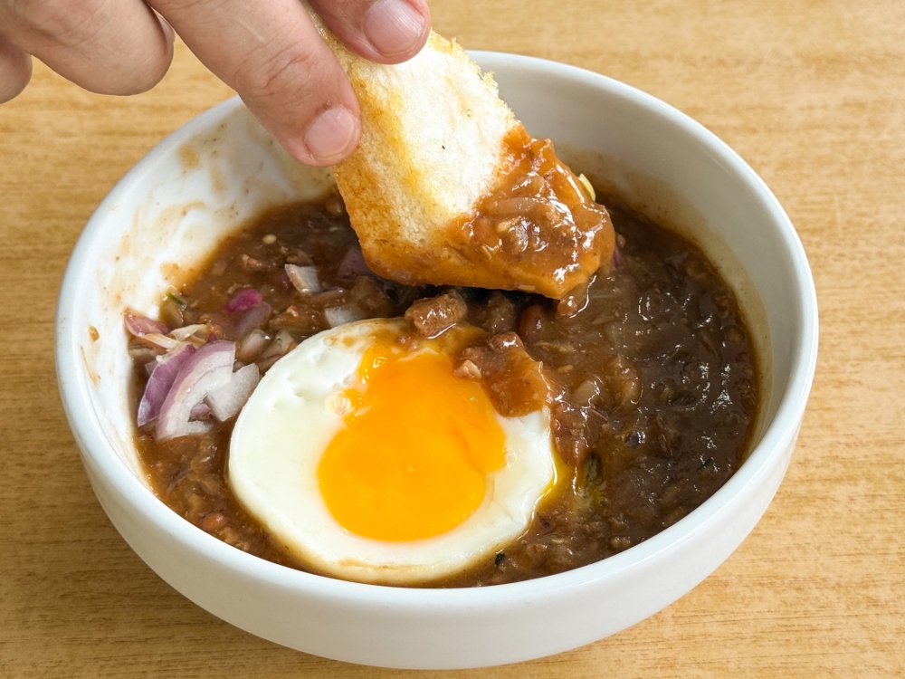 Dunk a piece of the ‘roti bakar’ to scoop up a bit of the stew. — Picture by Lee Khang Yi