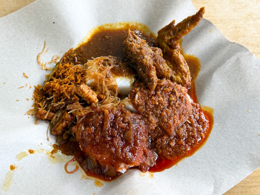 Mess alert! Lontong Kering is best mixed together to get flavour with ‘rendang’ chicken. — Picture by Lee Khang Yi