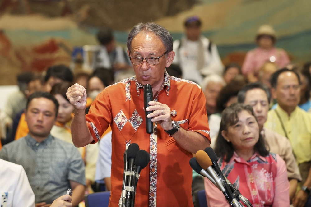 Denny Tamaki (2nd L) speaks to media after reports projected his defeat in the Okinawa gubernatorial election, in Naha, Okinawa prefecture on September 13, 2026. — AFP pic