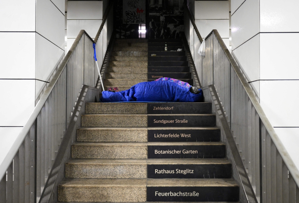 A homeless person in a sleeping bag lies on the stairs of the Anhalter Bahnhof S-Bahn public transport commuter train station in Berlin on February 23, 2026. — AFP pic