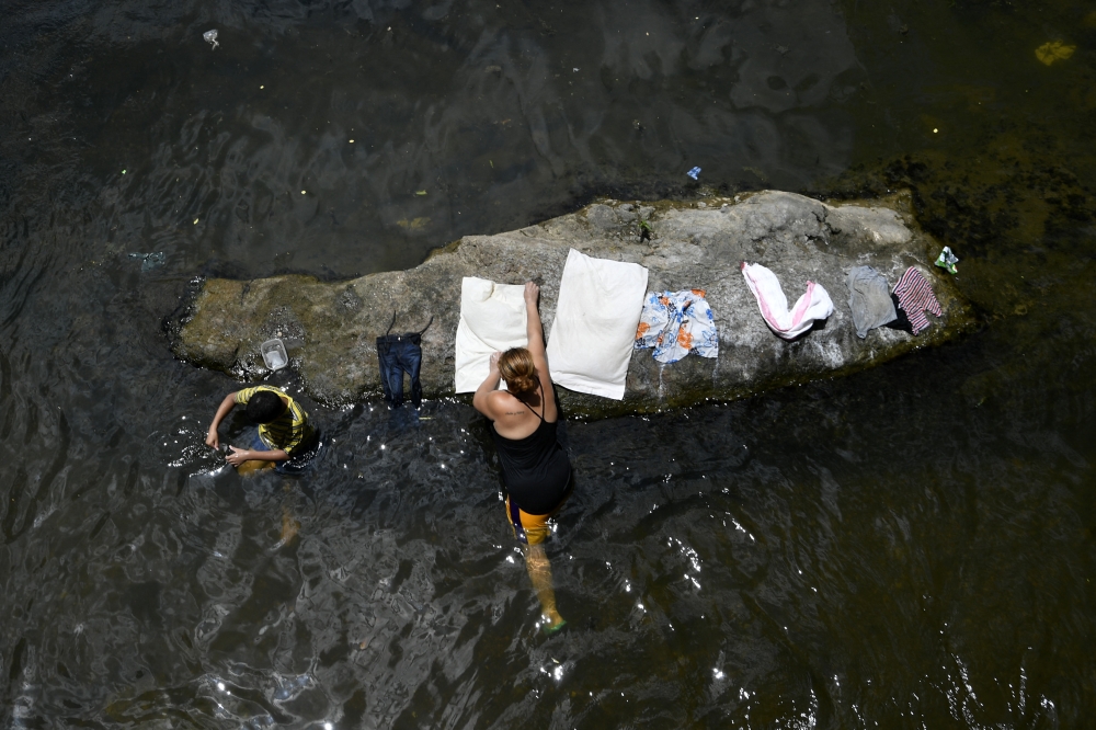A woman washes clothes in a river near the village of Los Piches in San Lorenzo, Department of Valle, Honduras September 4, 2026. — AFP pic