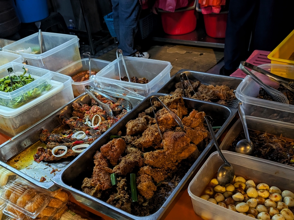Before sunrise is the best time to arrive, when the trays of many different ‘lauk’ are still mostly full and ripe for the picking. — Pictures by Ethan Lau