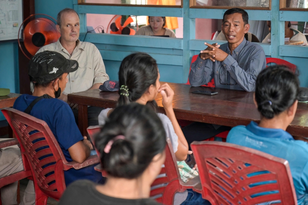 Erik Meijaard (left), managing director of Borneo Future, and Nardiyono (right), director of Borneo Future Indonesia, talk about a new conservation programme to rope in local villagers during a session in Sungai Ajung village in Kapuas Hulu, West Kalimantan on September 2, 2026. — AFP pic