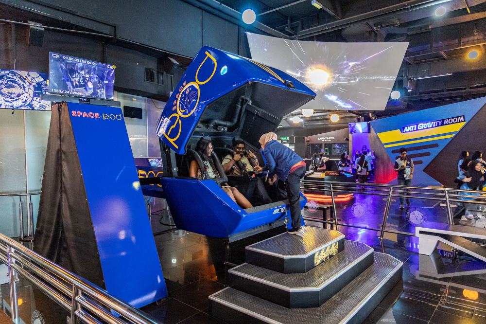 Visitors experiencing the Spacepod, a two-seater cockpit simulator that provides screenings offering an exploration and flight experience into outer space, with three-axis movement and 360-degree freedom of movement.