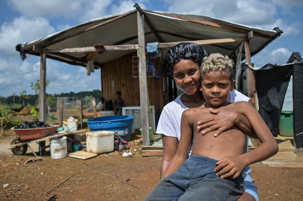 Thais Pereira de Souza, 32, poses for a photo with her son in front of their home in the Nova Conquista neighborhood in Oiapoque, Amapa state, Brazil on September 4, 2026. Residents are caught between hopes of an economic boom and fears of an oil spill. — AFP pic