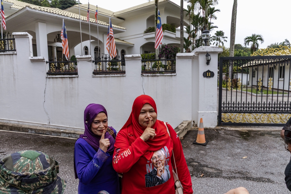 Supporters of Datuk Seri Najib Razak pose outside the Kuala Lumpur home of the former prime minister on September 18, 2026. The 73-year-old has been granted a conditional royal pardon allowing him to serve the remainder of his prison sentence under house arrest, subject to payment of the RM50 million fine and compliance with conditions that have not been publicly disclosed. — Picture by Firdaus Latif