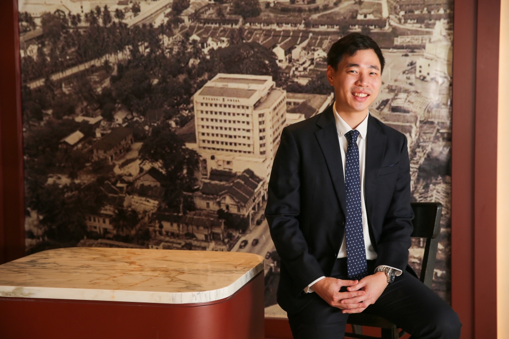 Low Yat Group business development manager Low Kian Leong pictured against an archival image of The Federal Kuala Lumpur and its surrounding Bukit Bintang neighbourhood. — Picture by Choo Choy May