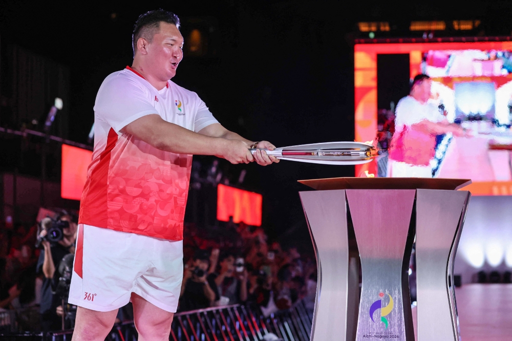 Former ‘yokozuna’ Hakuho carries the flame during the torch relay ahead of the 2026 Asian Games in Nagoya on September 18, 2026. — Jiji Press pic via AFP