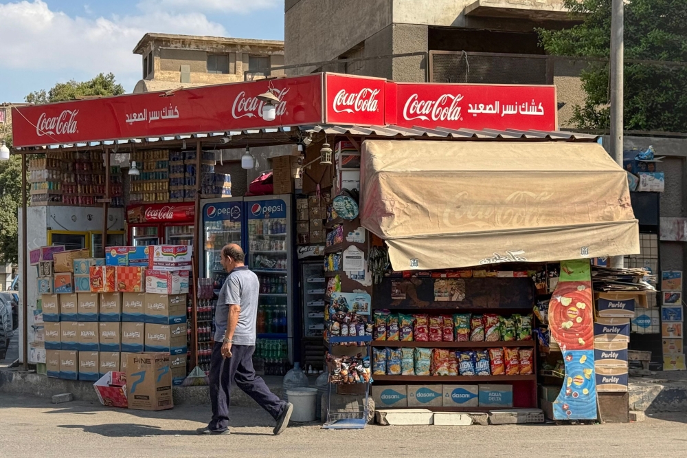 A man walks past a traditional sidewalk kiosk in Cairo on September 18, 2026. Cairo's omnipresent street kiosks, where commuters grab cigarettes, children buy sweets, and residents stop for cold drinks or phone credit, are set for a makeover that some fear could price many small operators out of business. Authorities in the Egyptian capital this week launched a scheme to standardise thousands of licensed kiosks, giving existing operators three months to adopt a unified design costing between 50,000 and 60,000 Egyptian pounds ($1,000-$1,200), a hefty sum for many small business owners. — AFP pic