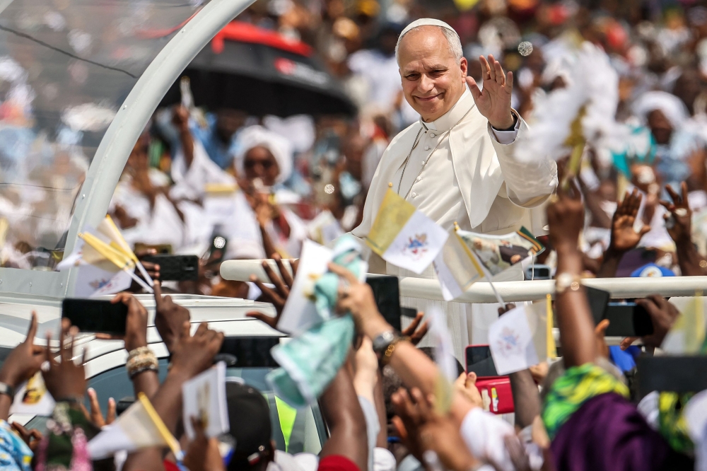 Pope Leo XIV waves to the crowd from the pope-mobile as he arrives to lead the Holy Mass in Douala on the fifth day of an 11-day apostolic journey to Africa, on April 17, 2026. — AFP pic