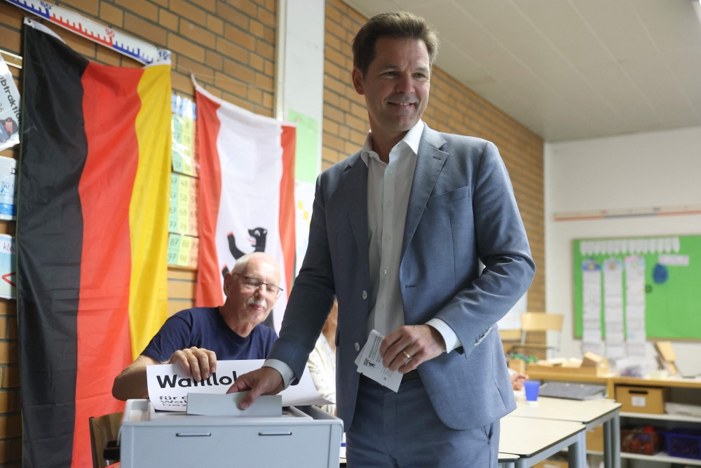 The top candidate of the social democratic SPD party Steffen Krach (R) casts his ballot at a polling station in Berlin during regional elections in the German capital on September 20, 2026. — AFP pic