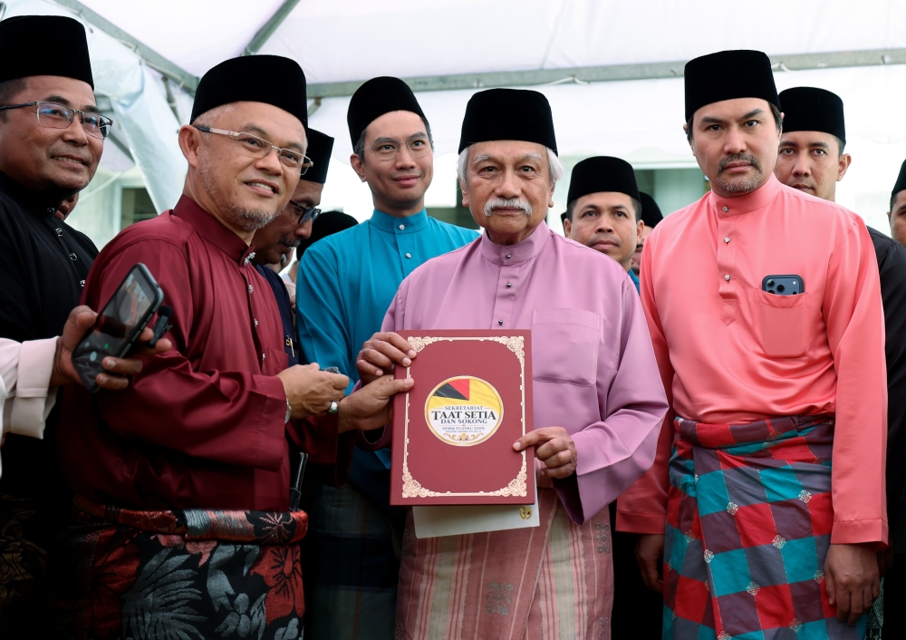 Yang di-Pertuan Besar of Negeri Sembilan Tuanku Muhriz Tuanku Munawir (centre) receives a memorandum from non-governmental organisations, presented by Prof Dr Mohd Aluwi Sari, after Friday prayers at the Tuanku Munawir Royal Mosque in Seri Menanti on September 18, 2026. The Negeri Sembilan Ruler’s powers and the role of the Menteri Besar are at the centre of a constitutional dispute over the state executive council. — Bernama pic