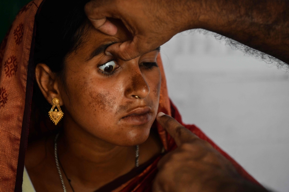 A woman is being examined by a doctor inside a mobile boat clinic on the banks of the Brahmaputra River in the Mukalmua village of Assam’s Nalbari district September 19, 2026. — AFP pic