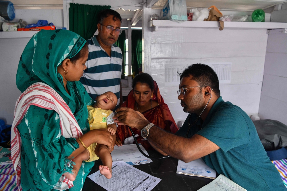 A doctor examines a child inside a mobile boat clinic in the Mukalmua village of Assam’s Nalbari district September 19, 2026. — AFP pic