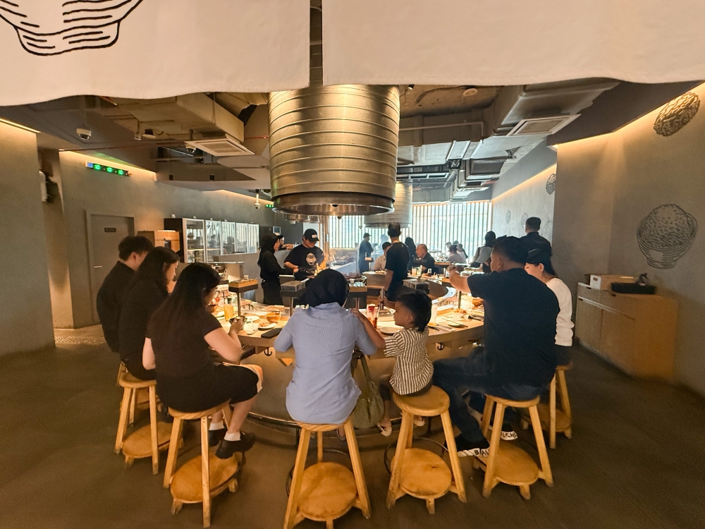 The set-up is minimalist with a round-shaped counter surrounding the charcoal grill to give you a front row view of the cooking action. 