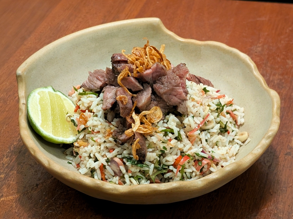 A local outlier on the menu, AG. Deli’s ‘nasi ulam’ comes topped with Wagyu burnt ends. — Picture by Ethan Lau
