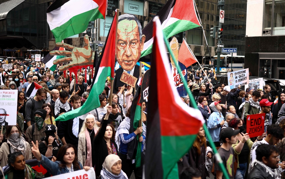 Protesters hold an image of Israeli Prime Minister Benjamin Netanyahu bearing the word ‘Criminal’ above a crowd waving Palestinian flags and holding ‘Free Palestine’ signs during a demonstration on the day of his address to the 81st United Nations General Assembly in New York September 24, 2026. — AFP pic