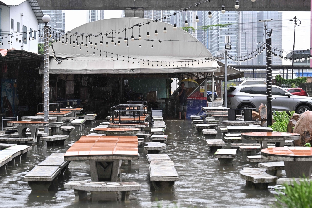 A man looks out from a flooded restaurant in Bangkok on September 26, 2026. — AFP pic