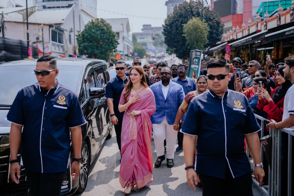 Indian actress Tamannaah Bhatia smiles and waves to fans as she arrives at Yazhini Gold & Diamonds in Jalan Segget, Johor Baru. 