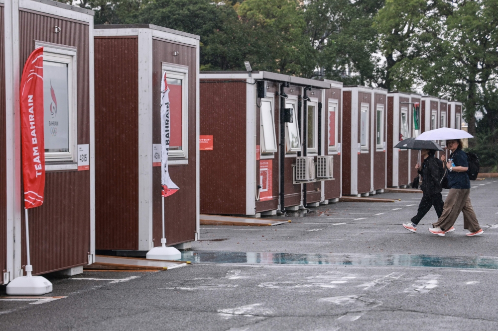 Officials walks past temporary container huts during a press tour of the athletes’ village during the 2026 Asian Games at the Garden Pier in Nagoya September 27, 2026. — AFP pic