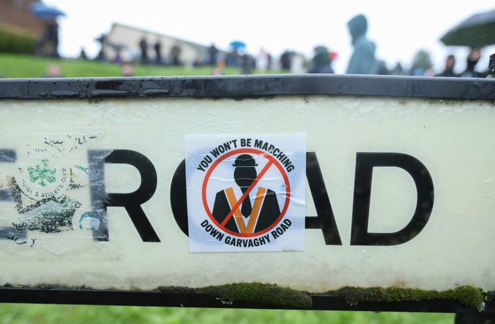 Stickers cover a road sign as a crowd of protesters gather to block the Garvaghy Road in Portadown, Northern Ireland in the morning of September 27, 2026, to prevent a parade of marchers from the Orange Order using the route through the mainly nationalist area of the town. — AFP pic