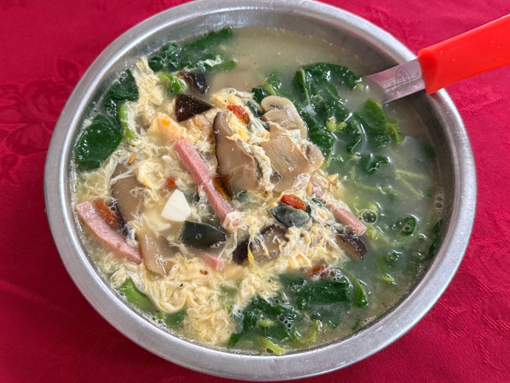 ​​​​​​​This bowl of spinach in a broth, topped with the frilly strands of a beaten egg, tastes just like home. — Picture by Lee Khang Yi