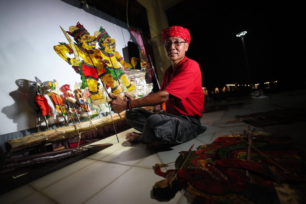 Kelantan ‘wayang kulit’ practitioner Kang Boon Ann, 58, who is also founder of the Sri Cindayu Wayang Kulit Association, displays a character he created after performing a ‘wayang kulit’ show at Tok Bali Jetty, Pasir Puteh. — Bernama pic 
