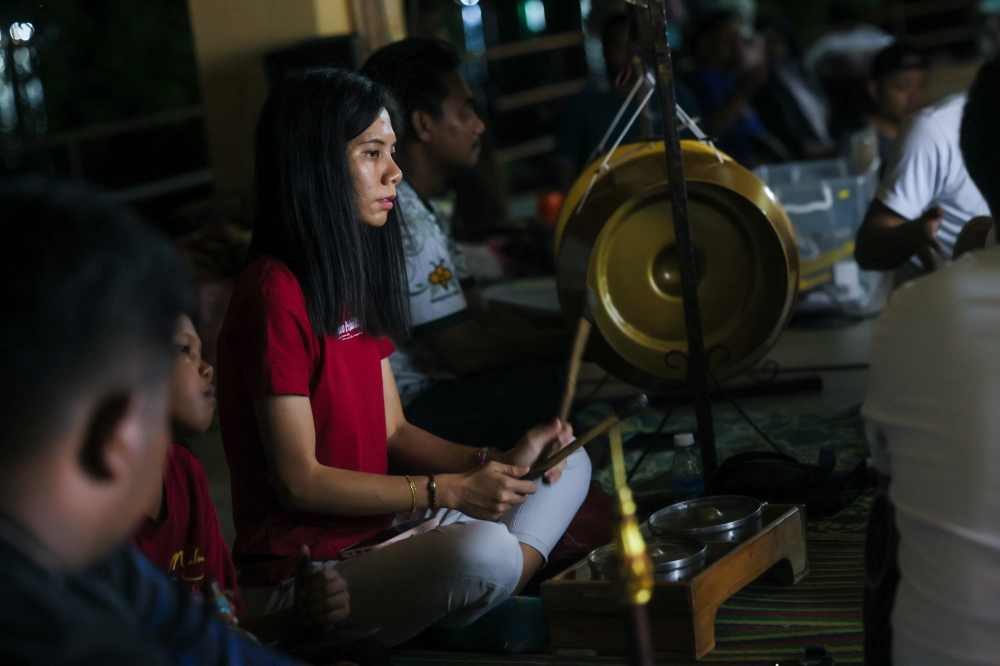 Sri Cindayu Wayang Kulit Association founder Kang Boon Ann’s daughter, Kang Siew Lie, 32, skilfully plays a musical instrument during a wayang kulit performance, a traditional form of shadow puppetry, at Tok Bali Jetty, Pasir Puteh, recently. — Bernama pic 