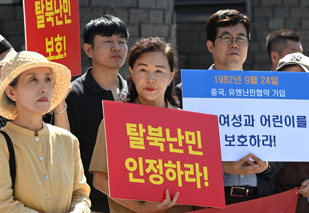 A North Korean defector (centre) living in South Korea holds a placard reading ‘Recognise North Korean refugees!’ during a rally calling to stop China’s forced repatriation of North Korean defectors in front of the Chinese embassy in Seoul September 22, 2026. — AFP pic