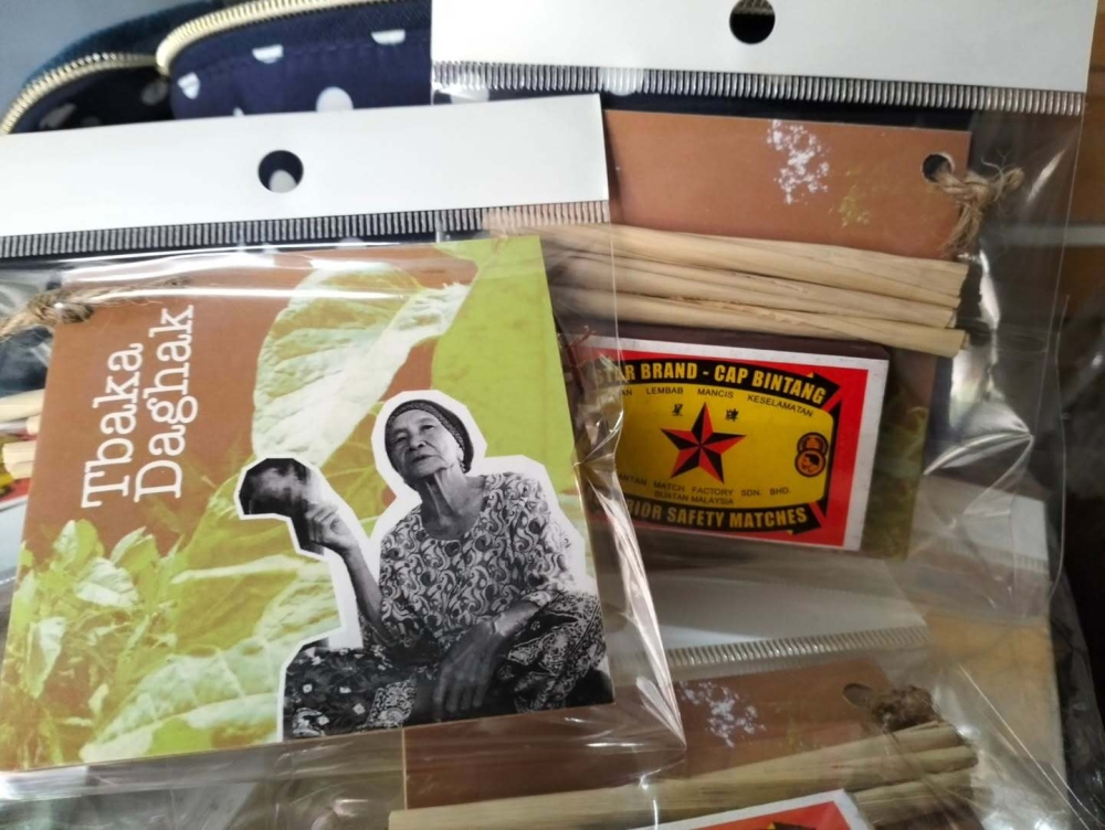 Zaidi would package his ‘Tbaka Daghat’ postcards along with complimentary leaf cigarettes and a box of locally made matches. — Picture via Instagram/Kedai Hitam Putih