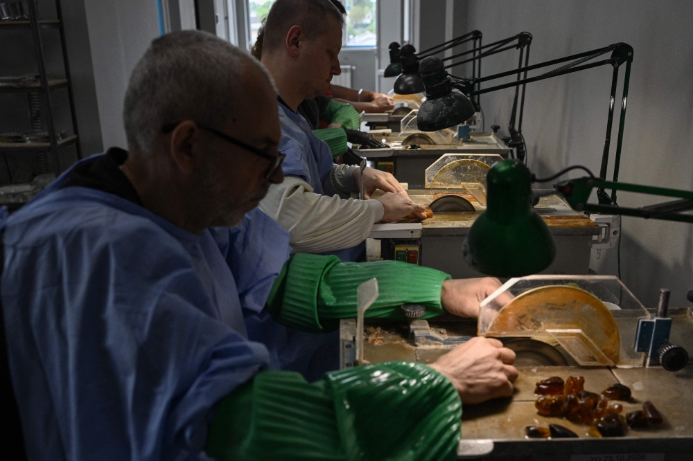 Employees process amber at a production facility of the Amber Galbin group in Rivne. — AFP pic