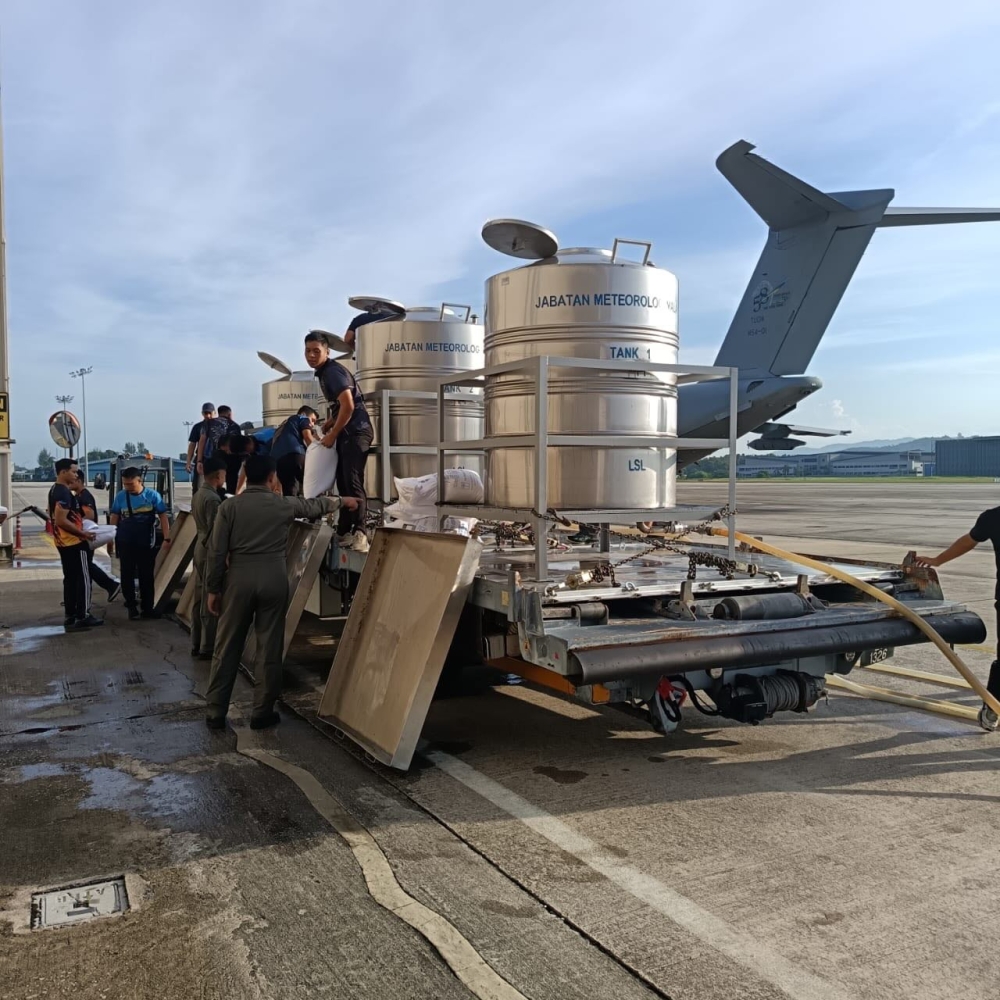 MetMalaysia personnel prepare a saltwater mixture for cloud seeding before loading the barrels onto an RMAF aircraft at the Subang airbase for operations in Perlis and Kedah on May 11, 2026. — Picture from Facebook/National Disaster Management Agency, Prime Minister’s Department
