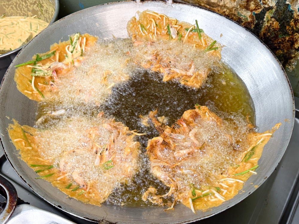 This frying method sees thin crispy crackers clinging to the side of the wok in hot oil. — Picture by Lee Khang Yi
