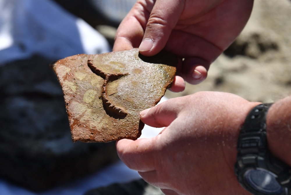 Maxim Menshikov, archaeologist and the expedition director, and fellow colleagues inspect the finds discovered by divers at the underwater site on the bed of Lake Issyk-Kul of what is identified by researchers as a submerged medieval city on the Silk Road in the settlement of Toru-Aygyr in Kyrgyzstan on September 22, 2026. Situated on an ancient trading route between China and Europe, little is known about the history of the settlement under Kyrgyzstan's largest lake or how it came to be flooded an estimated 800 years ago. The settlement is located at the heart of what was once the Silk Road, a trading route that linked China to the Mediterranean from the 2nd century BC until the mid-15th century. — AFP pic