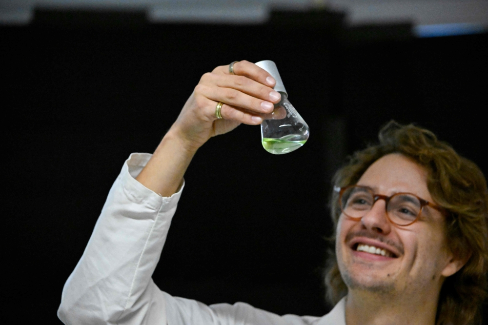 German scientist Darius Rauch holds a flask containing unicellular green algae at German scientist Peter Hegemann’s laboratory at Humboldt University in Berlin on October 5, 2026, after Hegemann is named a winner of the 2026 Nobel Prize in Physiology or Medicine. — AFP pic