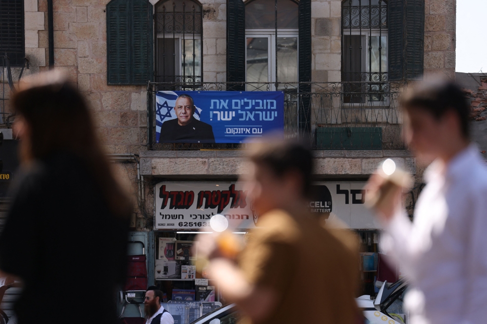 People walk past an election billboard bearing a portrait of Gadi Eisenkot, Israel’s former chief of the general staff and leader of the Yashar centrist political party, and seen as Prime Minister Benjamin Netanyahu’s rival in the coming October 27, 2026 polls. — AFP pic