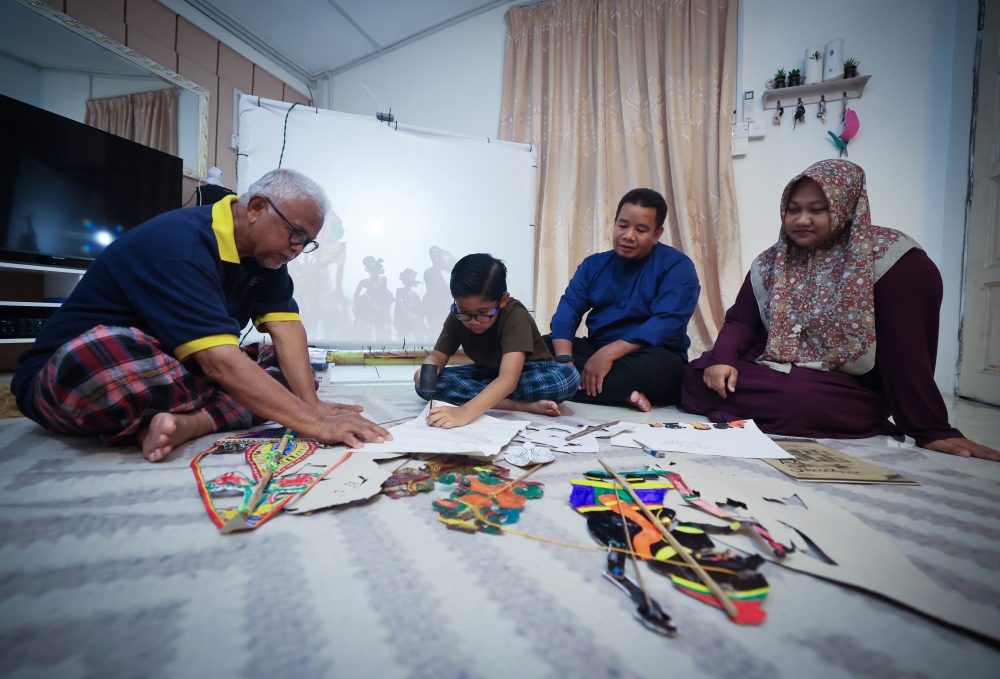 Nik Imanuddin Hadeef Nik Izdiharuddin, 10, receives strong support from his family as he pursues his interest in the traditional art of ‘wayang kulit’. — Bernama pic