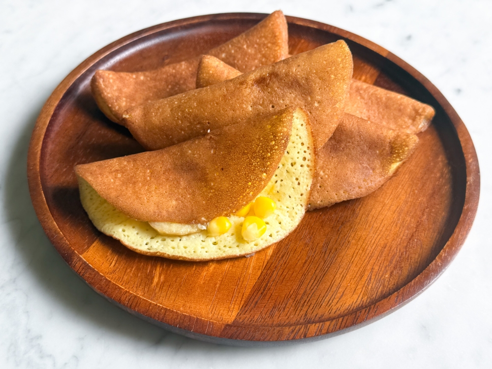 Apong Guan is famous for its fluffy, coconut scented 'apom' with bananas and corn niblets. — Picture by Lee Khang Yi