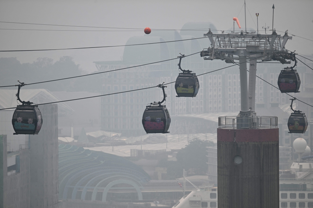 Cable cars travel to Sentosa island as haze shrouds Singapore on October 9, 2026. —  AFP pic