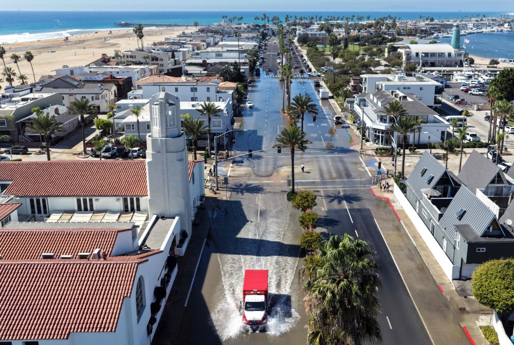 An aerial view shows an emergency vehicle driving through coastal floodwaters amid strong waves and high tides generated by Tropical Storm Rachel in Newport Beach, California, on October 9, 2026.  — AFP pic